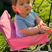 Isabella joined the competition — help win amazing prizes! toddler, child, outdoor, sunlight, pink_chair, grass, hands, clothing, portrait, baby, seat, greenery, person, young_child, casual, sitting, expression, cute, daylight, nature
