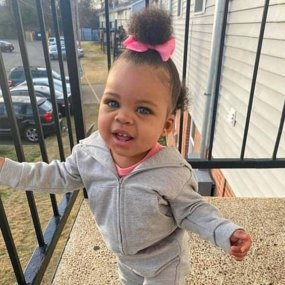 Ta'Leah is registered to the contest to win money with this photo: baby, baby_toddler_clothing, car, face, fun, grass, happy, head, leisure, mammal, person, recreation, skin, sleeve, smile, standing, tire, toddler, vertebrate, wheel