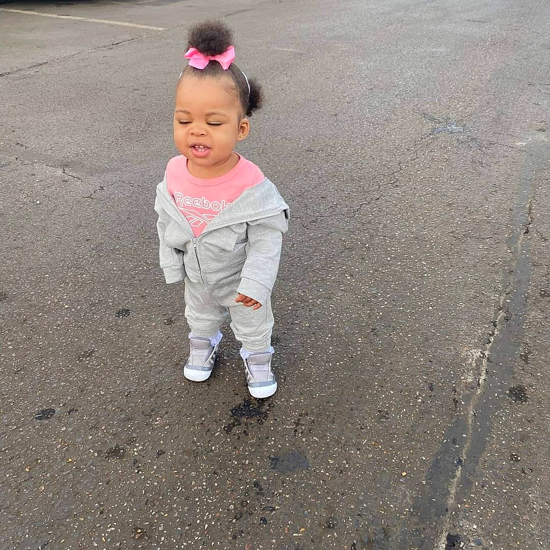 Ta'Leah is registered to the contest to win money with this photo: asphalt, child, concrete, face, fun, gesture, grass, happy, leg, people_in_nature, person, recreation, road, road_surface, sand, shadow, sidewalk, soil, tar, toddler