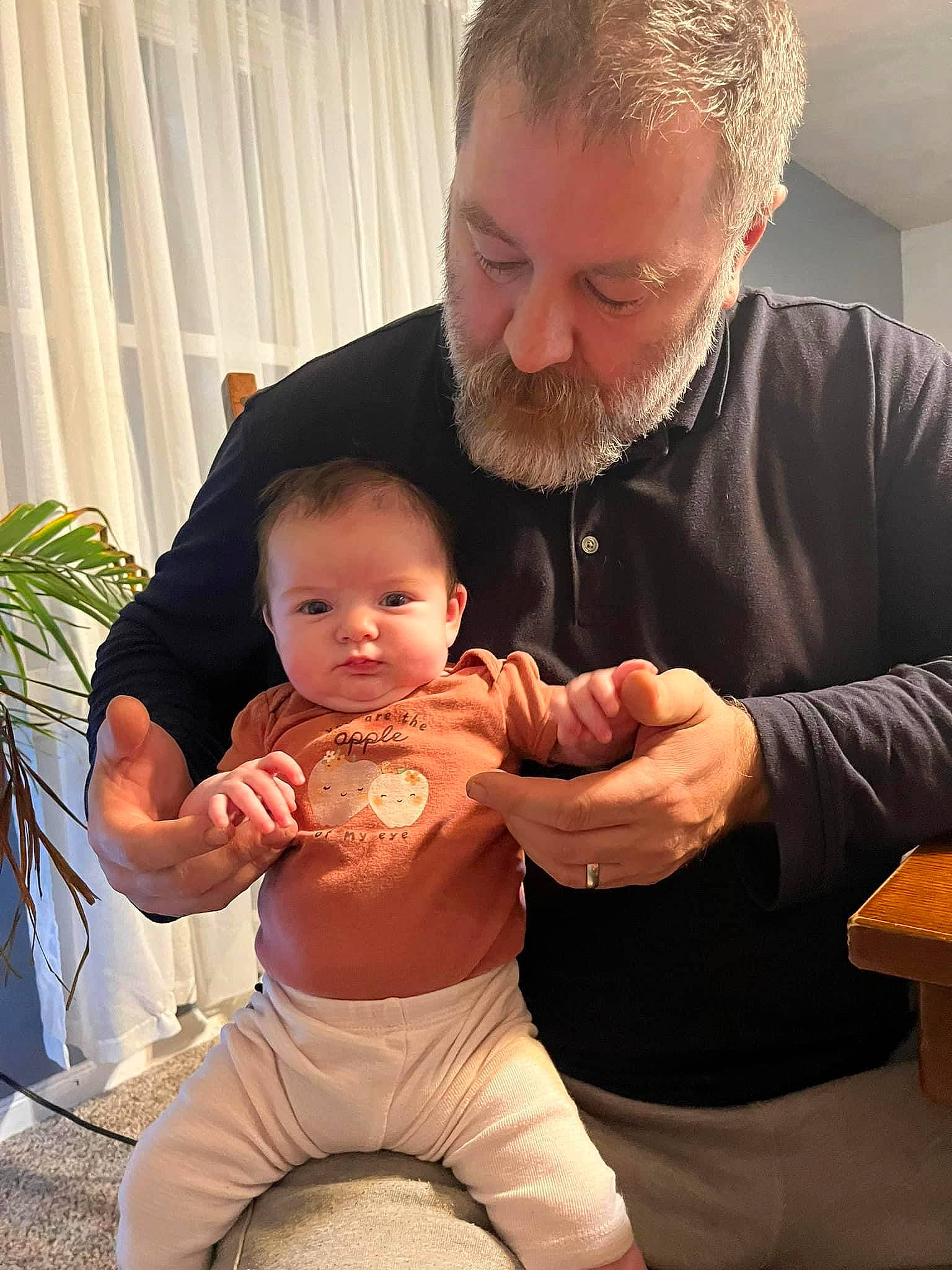 Lucy is registered to the contest to win money with this photo: abdomen, baby, baby_toddler_clothing, beard, child, curtain, event, food, gesture, happy, houseplant, lap, muscle, person, plant, shorts, sitting, stomach, thigh, thumb
