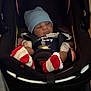 Damian is registered to the contest to win money with this photo: baby, infant, car_seat, blue_hat, striped_socks, pacifier, clothing, black, indoor, child, seatbelt, newborn, cute, resting, person, portrait, young, wearing_hat, baby_boy, comfort