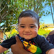 Aaron participe au concours pour gagner de l'argent avec cette photo : toddler, child, smiling, flower, ear, hand, arm, outdoor, plants, tree, greenery, sunlight, shirt, colorful, person, portrait, happy, nature, daylight, baby