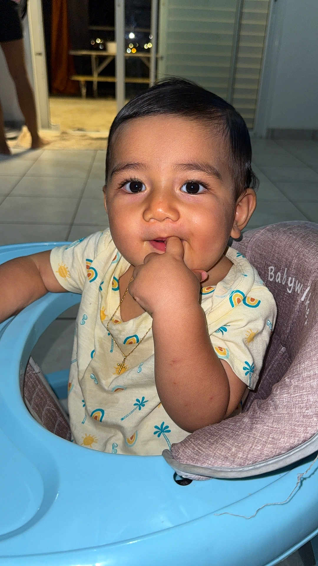 Aaron participe au concours pour gagner de l'argent avec cette photo : baby, child, infant, walker, finger_in_mouth, gold_necklace, cross_necklace, curly_hair, big_eyes, tiled_floor, indoor, person, cute, sitting, expression, hand, clothing, high_chair, face, portrait