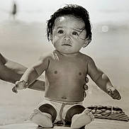 Seven a rejoint le concours — aidez-le/la à gagner de superbes lots ! baby, child, surfboard, beach, water, ocean, black_and_white, wet_hair, person, portrait, sitting, hands, expression, cute, young, summer, vacation, outdoor, support, foot