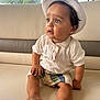 Seven participe au concours pour gagner de l'argent avec cette photo : toddler, child, hat, blue_eyes, white_polo_shirt, knitted_shorts, sitting, leather_couch, indoor, curious, natural_light, skin, foot, hand, face, expression, portrait, baby, cute, comfortable