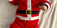 Alex participe au concours pour gagner de l'argent avec cette photo : baby, blanket, child, childrens_fashion, christmas, cute, face, festive, footwear, happy, hat, holiday, indoors, infant, lying_down, person, red_clothing, santa_claus_costume, smiling, warm_clothing