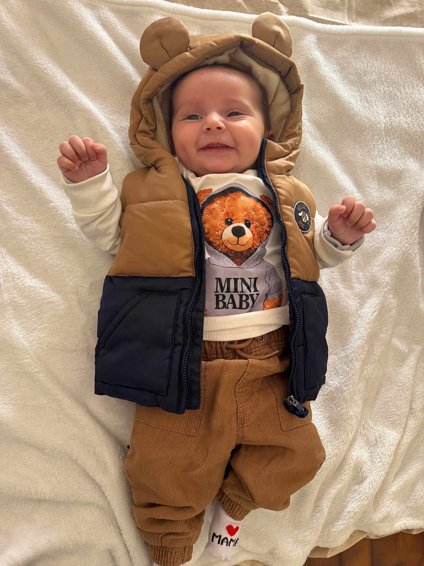 Alex a rejoint le concours — aidez-le/la à gagner de superbes lots ! baby, infant, smile, cute, clothing, hood, bear_ears, vest, pants, sock, lying_down, blanket, indoor, happy, child, portrait, soft_texture, casual_wear, baby_fashion, cozy