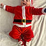 Alex participe au concours pour gagner de l'argent avec cette photo : baby, infant, santa_claus_costume, red_clothing, white_trim, baby_hat, smiling, lying_down, blanket, holiday, christmas, cute, happy, festive, footwear, soft_texture, child, person, indoors, celebration