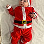 baby, infant, santa_claus_costume, red_clothing, white_trim, hat, booties, blanket, lying_down, cute, holiday, christmas, festive, child, face, expression, indoors, soft_texture, warm_clothing, adorable