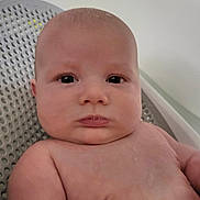 Devin is registered to the contest to win money with this photo: baby, infant, face, skin, expression, eyes, shoulders, chest, sitting, chair, plastic, indoor, portrait, closeup, child, young, cute, human, person, head