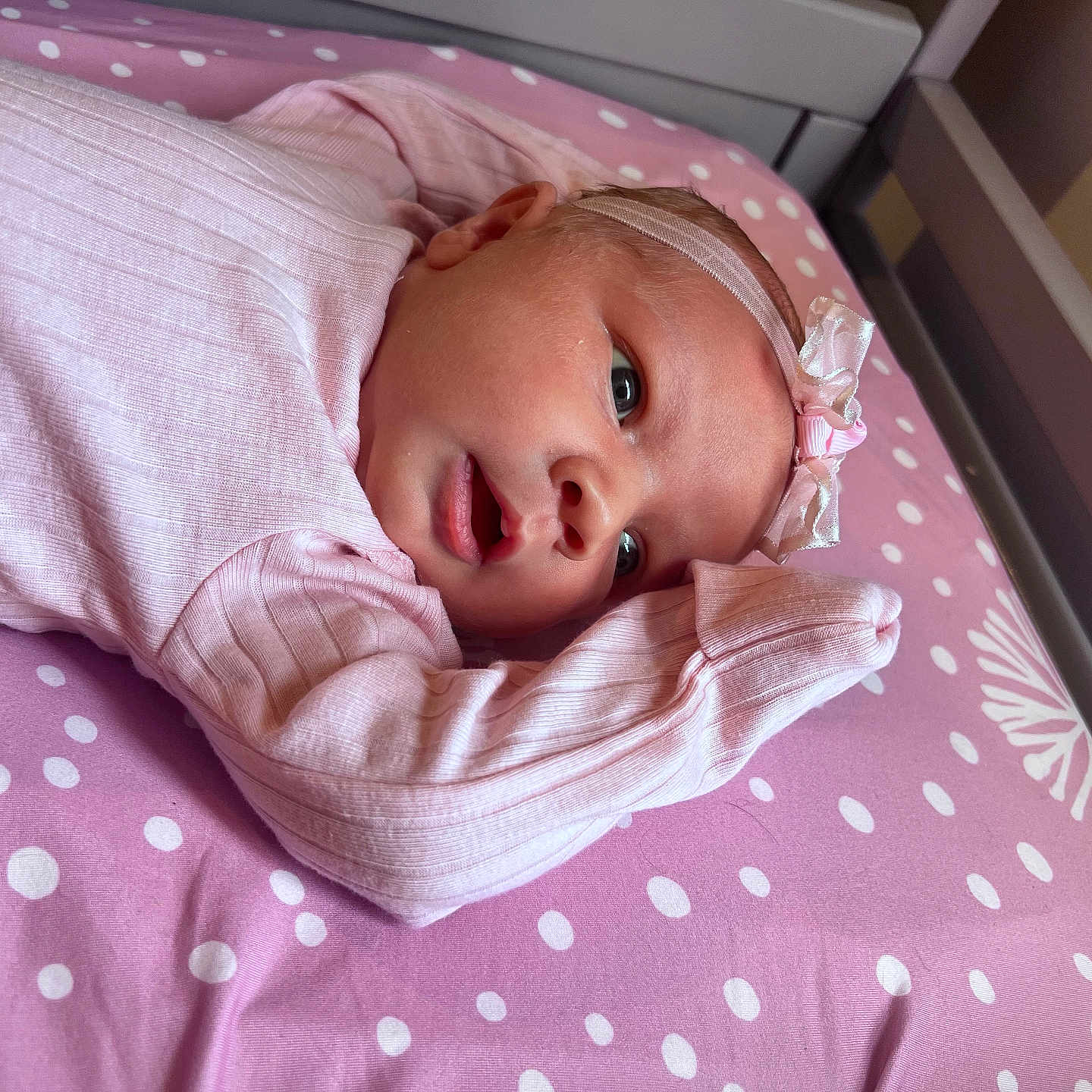 Saige is registered to the contest to win money with this photo: baby, bed, blanket, bodypart, bonnet, clothing, crib, cushion, face, finger, furniture, hand, hat, head, homedecor, infantbed, newborn, person, photography, portrait