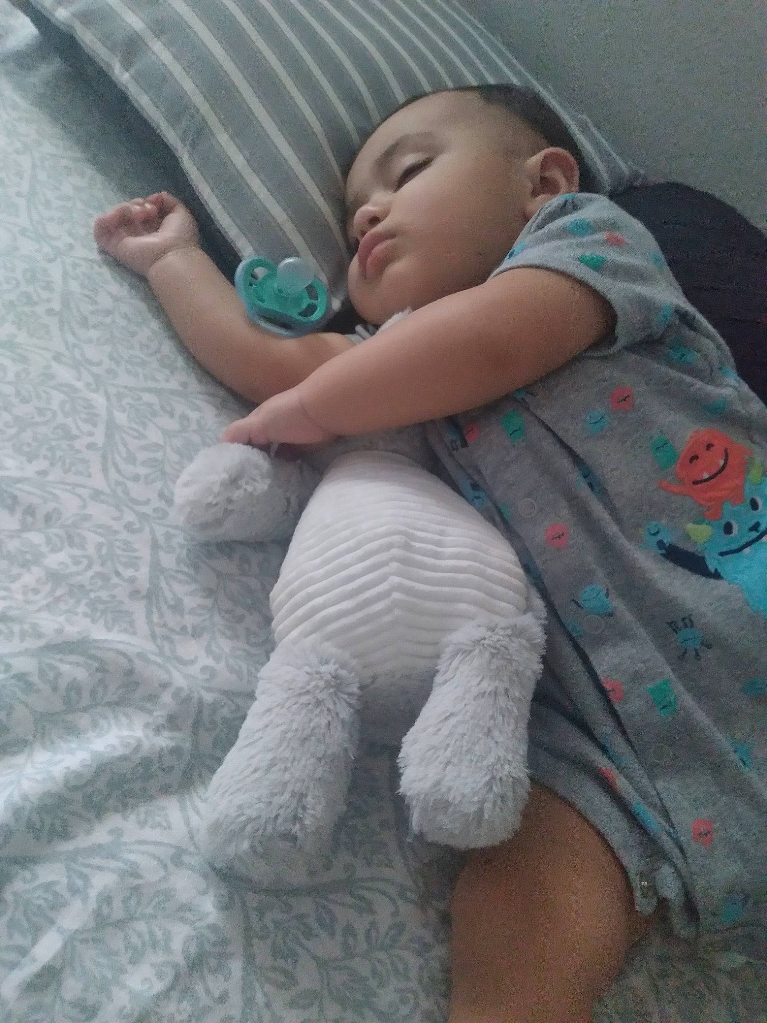 Christian is registered to the contest to win money with this photo: baby, baby_products, baby_toddler_clothing, child, comfort, elbow, finger, grey, human_leg, knee, linens, pattern, person, sitting, skin, sleeve, sock, t_shirt, textile, thigh