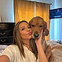 Bailee is registered to the contest to win money with this photo: woman, dog, golden_retriever, bedroom, selfie, curtains, television, bed, furniture, smile, pet, indoor, portrait, person, animal, casual_clothing, light, face, hand, cozy