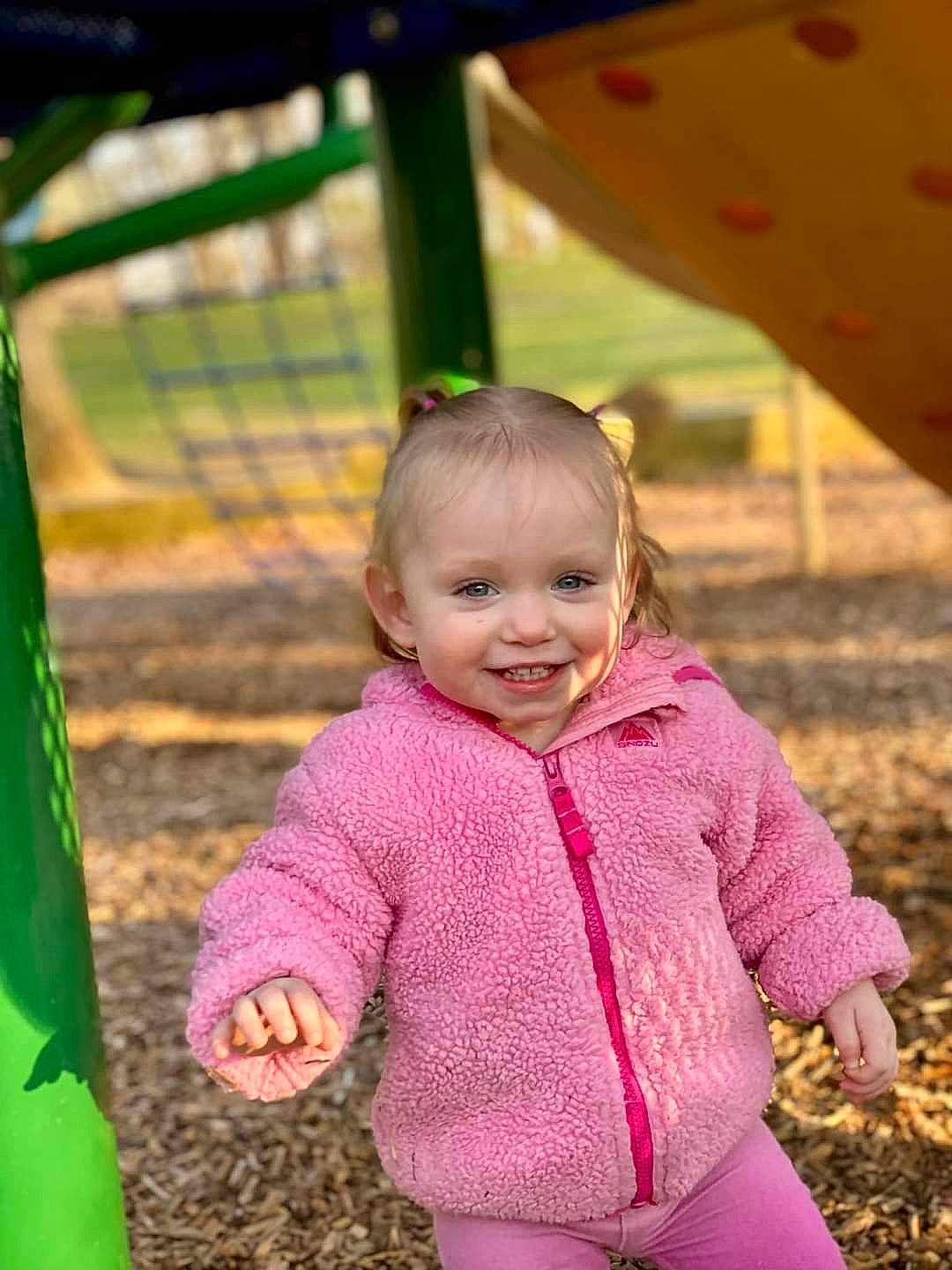 Gabriella is registered to the contest to win money with this photo: baby, baby_toddler_clothing, child, city, fun, grass, green, happy, jacket, joy, leisure, outdoor_play_equipment, people_in_nature, person, playground, recreation, skin, sleeve, smile, soil