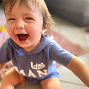 Gabriel a rejoint le concours — aidez-le/la à gagner de superbes lots ! toddler, child, smiling, happy, laughing, blue_hoodie, sitting, indoor, floor, cute, baby, casual_clothing, playful, young_child, face, person, closeup, expression, joyful, blurry_background