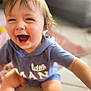 toddler, child, smiling, happy, laughing, blue_hoodie, sitting, indoor, floor, cute, baby, casual_clothing, playful, young_child, face, person, closeup, expression, joyful, blurry_background