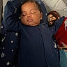 baby, sleeping, onesie, navy_blue, plush_toy, cushion, stars, indoor, infant, peaceful, child, face, closed_eyes, soft_toys, bedtime, cute, relaxing, comfort, fabric, portrait