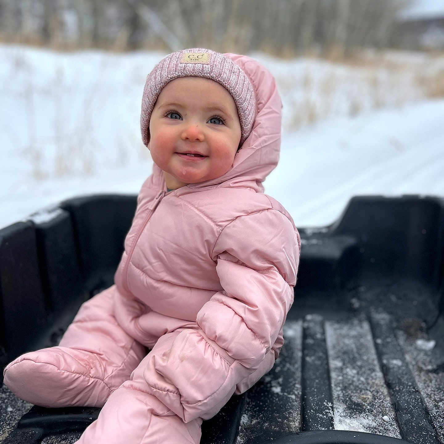 Serenie is registered to the contest to win money with this photo: baby, cap, clothing, coat, face, glove, happy, hat, head, hood, jacket, nature, outdoors, pants, person, photography, portrait, sitting, smile, snow