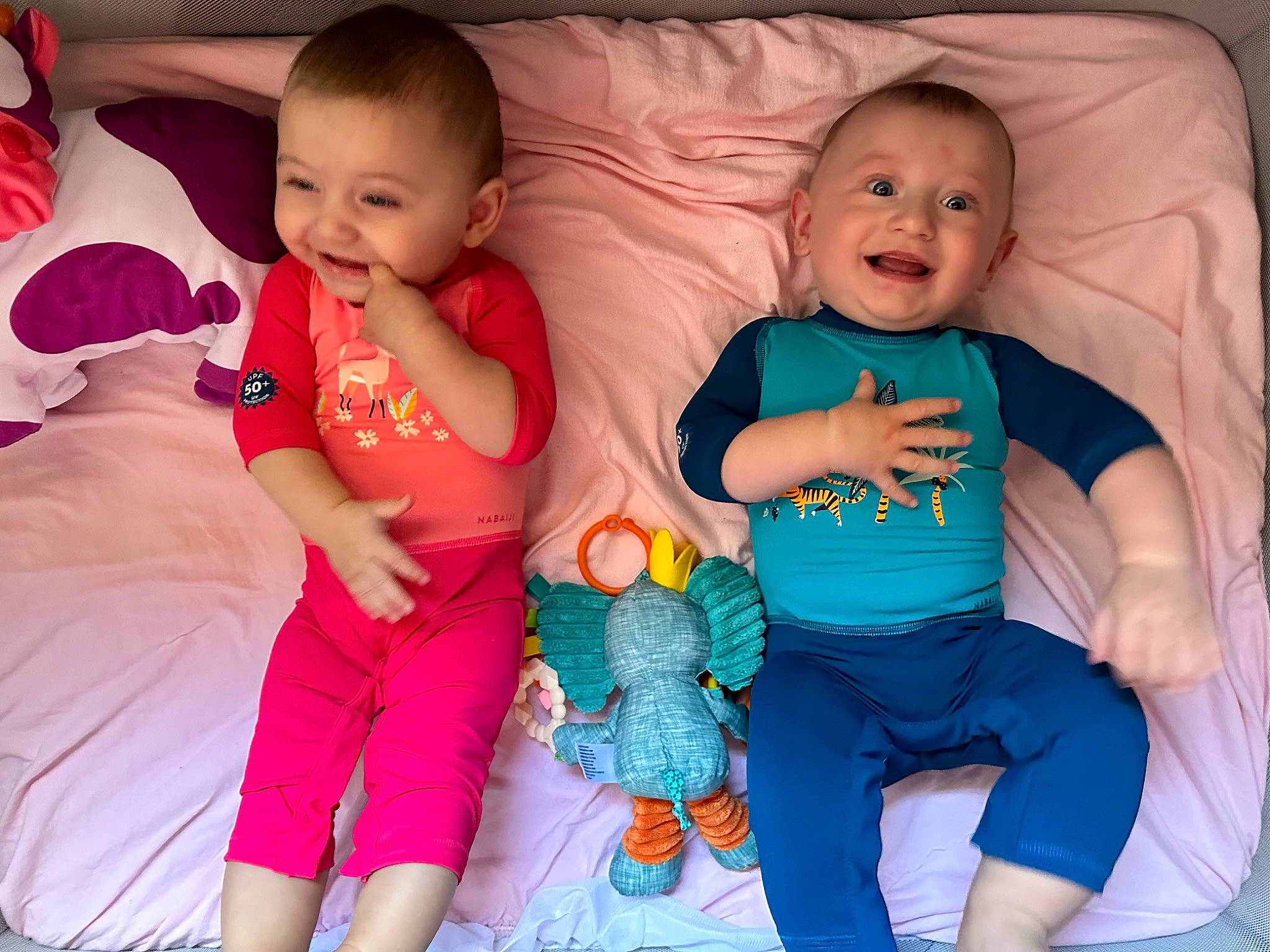 Gabin participe au concours pour gagner de l'argent avec cette photo : baby, baby_toddler_clothing, cheek, comfort, face, facial_expression, finger, happy, human_body, interaction, iris, joy, mouth, person, pink, product, skin, smile, standing, t_shirt