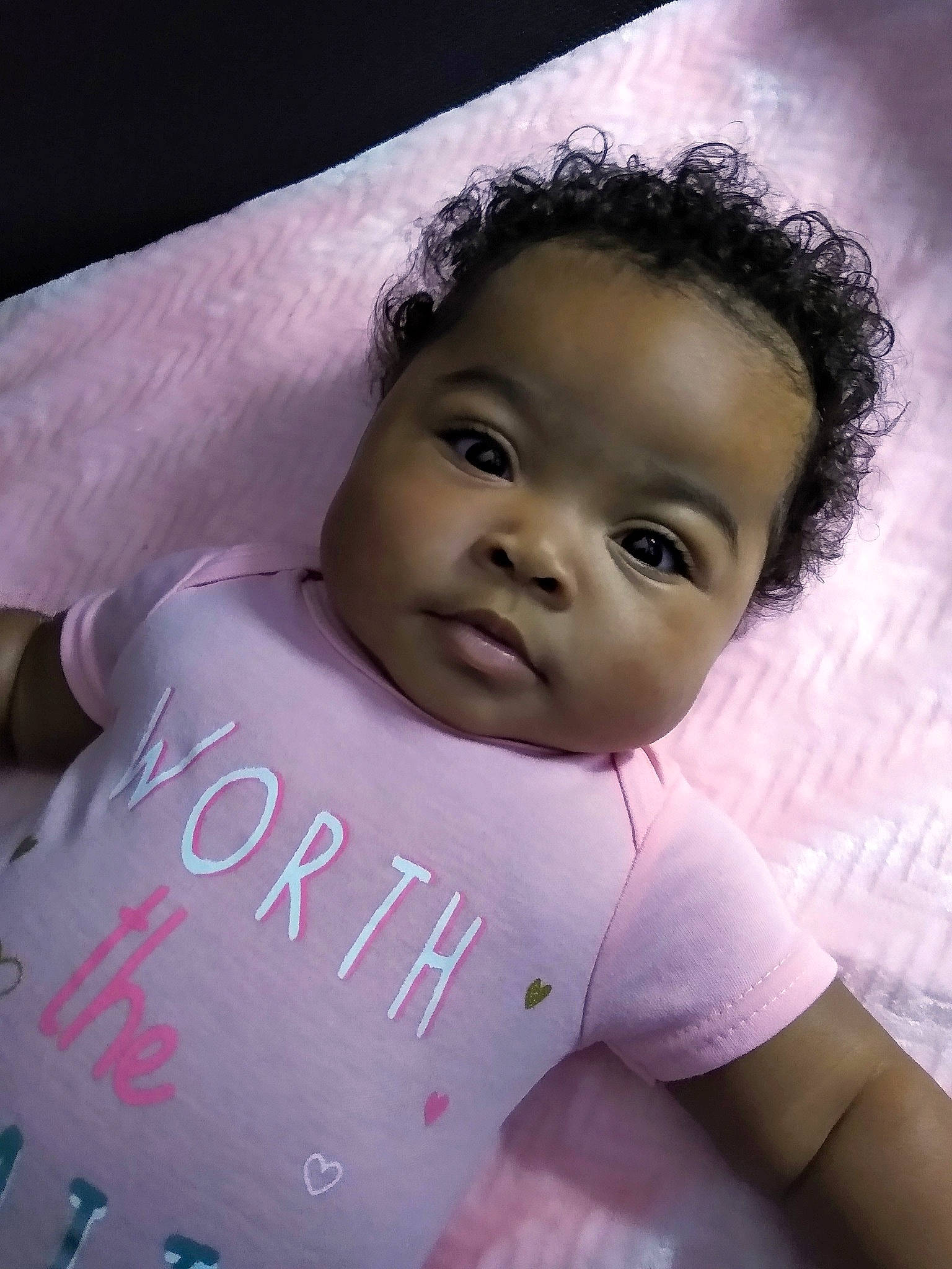 June is registered to the contest to win money with this photo: arm, baby, baby_toddler_clothing, cheek, chin, eye, eyebrow, eyelash, face, flash_photography, hairstyle, happy, lip, material_property, nose, person, pink, skin, sleeve, smile