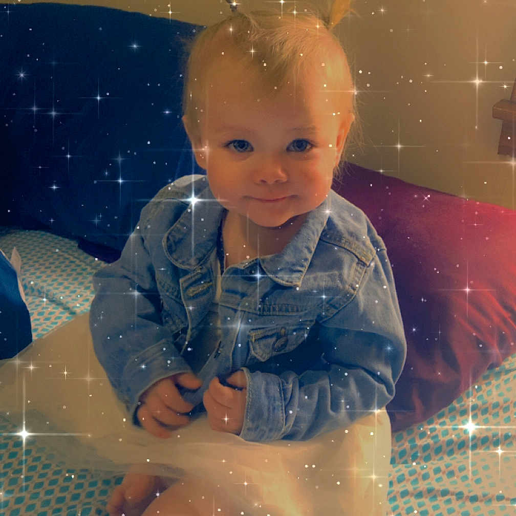 Zailiah is registered to the contest to win money with this photo: bed, blue, child, clothing, cushion, cute, denim_jacket, feet, happy, indoor, pattern, person, pigtails, portrait, sitting, smiling, sparkle_filter, toddler, tutu, white