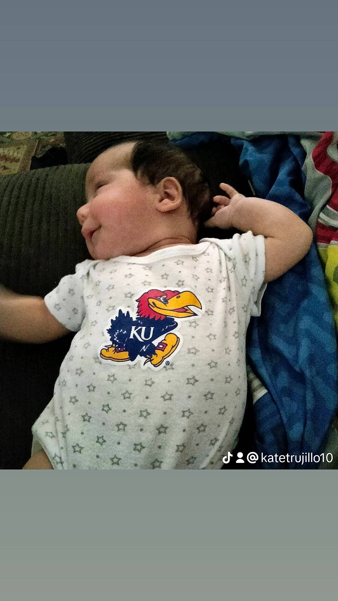 Waylen is registered to the contest to win money with this photo: baby, baby_products, baby_sleeping, baby_toddler_clothing, bedtime, child, comfort, cool, couch, facial_expression, font, grey, happy, linens, pattern, person, sitting, sleeve, sportswear, t_shirt