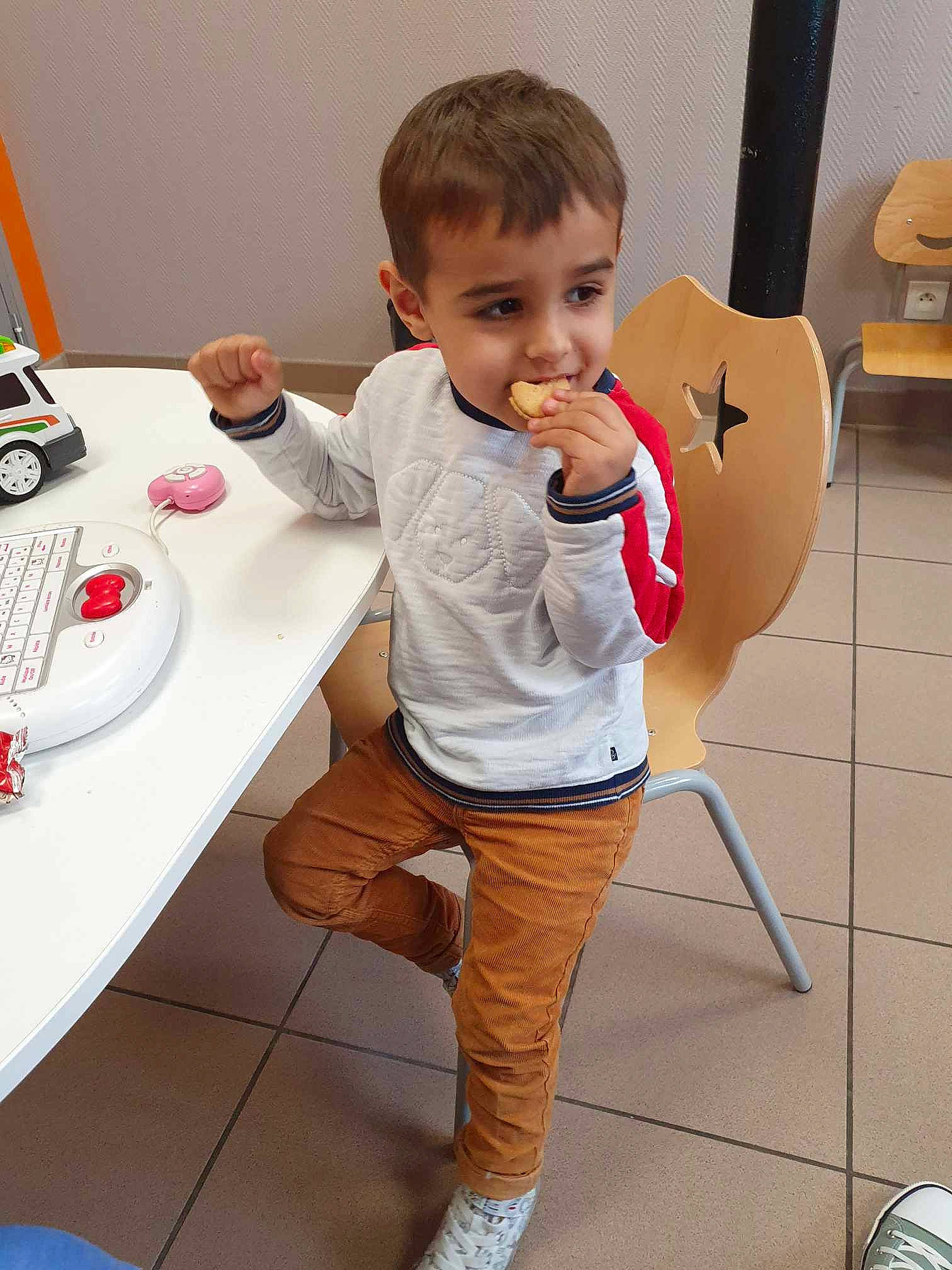 Nassim participe au concours pour gagner de l'argent avec cette photo : baby, baby_toddler_clothing, chair, desk, elbow, face, finger, flooring, human_leg, knee, leg, person, shorts, sitting, sleeve, t_shirt, table, tableware, telephone, thigh