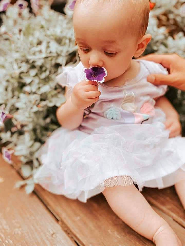 Halle joined the competition — help win amazing prizes! baby, baby_products, baby_toddler_clothing, cheek, child, dress, facial_expression, fashion_accessory, finger, hair_accessory, hand, person, photography, pink, product, ruffle, sitting, skin, smile, textile