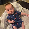 Levi is registered to the contest to win money with this photo: baby, infant, blanket, blue_clothing, usa_flag, romper, indoor, carpet, furniture, bookshelf, book, person, face, feet, hand, cute, child, young, relaxing, soft