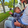 baby, man, smile, outdoor, grass, tree, tattoo, pajamas, happy, child, father, affection, person, daylight, nature, bonding, holding, casual_clothing, side_view, bench