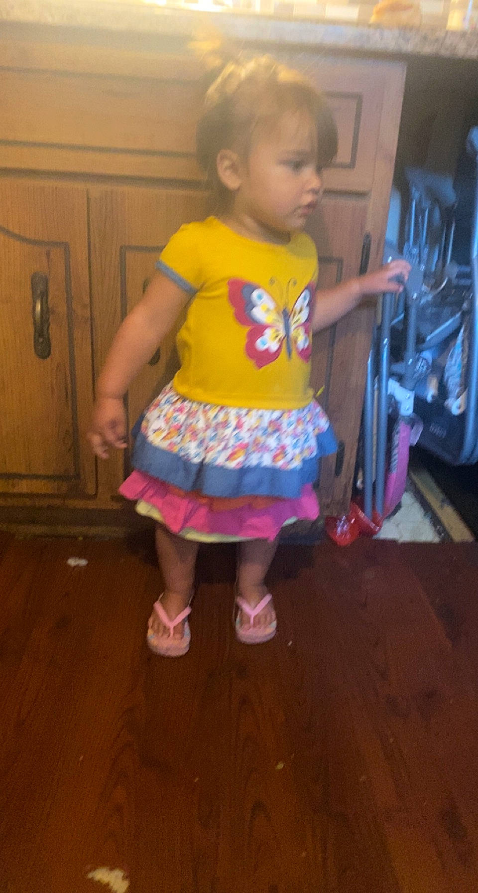 Kensleigh is registered to the contest to win money with this photo: baby, baby_toddler_clothing, barefoot, child, door, floor, flooring, fun, hardwood, human_leg, magenta, pattern, person, pink, purple, sandal, toddler, trunk, waist, wood