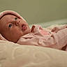 Elizabeth is registered to the contest to win money with this photo: baby, infant, pink_clothing, hood, blanket, lying_down, face, curious, indoors, soft_lighting, portrait, child, newborn, cute, warm, cozy, skin, expression, headwear, sleepwear
