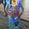 child, girl, mermaid_costume, lights, smiling, braids, indoor, carpet, floor, people, costume, purple, blue, long_sleeves, happy, portrait, holiday, celebration, standing, decorative_lights