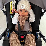 Talya participe au concours pour gagner de l'argent avec cette photo : baby, child, car_seat, hat, knit_hat, blue_eyes, infant, cozy_clothing, plush_outfit, sitting, seatbelt, indoor, floor_tiles, cute, hands, face, person, young_child, warm_clothing, portrait