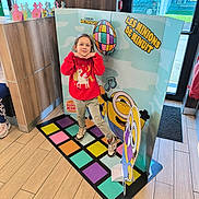 Rosalya a rejoint le concours — aidez-le/la à gagner de superbes lots ! advertisement, burger_king, cartoon, casual_clothing, child, colorful, daylight, decor, door, floor_mat, girl, glasses, indoor, minions, playful_pose, red_sweater, smile, unicorn, window, wooden_floor