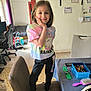 Rosalya a rejoint le concours — aidez-le/la à gagner de superbes lots ! certificate, chair, child, colorful_clothing, computer_chair, floor, girl, hairbrush, home, indoor, pants, pink_socks, shelf, smiling, standing, table, toys, tshirt, unicorn, window