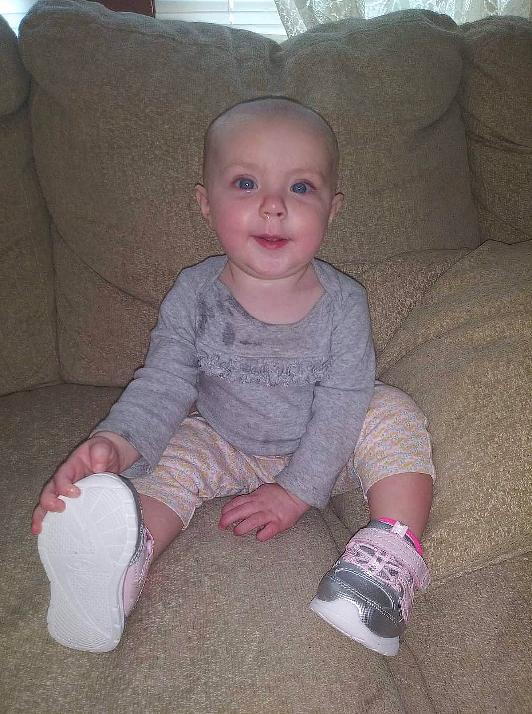 Emilee is registered to the contest to win money with this photo: baby, baby_toddler_clothing, chair, cheek, comfort, couch, finger, floor, flooring, foot, human_leg, knee, lap, leg, person, skin, sleeve, smile, sock, thumb