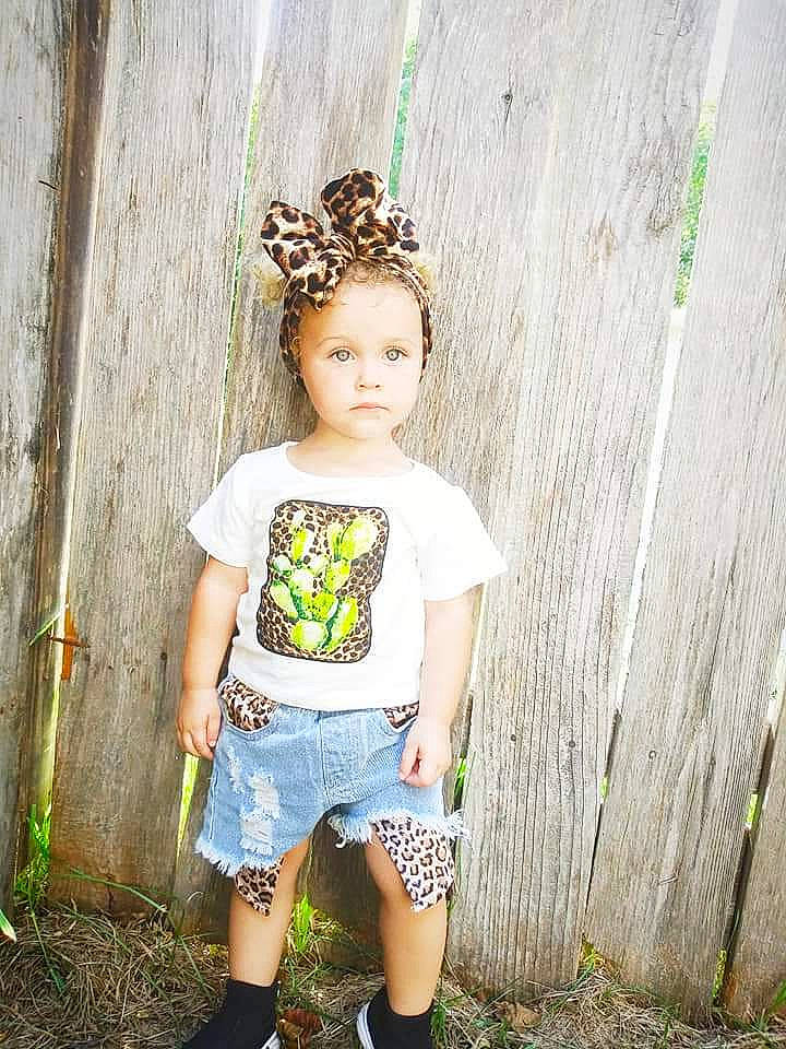 Trinity joined the competition — help win amazing prizes! baby_toddler_clothing, child, child_model, clothing, fashion_accessory, grass, green, headgear, pattern, person, photography, plant, shoe, shorts, sleeve, t_shirt, toddler, tree, yellow
