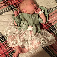 Becky joined the competition — help win amazing prizes! newborn, baby, sleeping, plaid_blanket, green_top, lace_skirt, infant, bed, soft_fabric, cute, peaceful, lying_down, cozy, indoors, person, small_hands, small_feet, wrapped, resting, child
