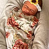 Kinsley is registered to the contest to win money with this photo: baby, newborn, smile, headband, flower, crocheted, blanket, floral_pattern, wrapped, cushion, soft, sleepy, cute, infant, portrait, resting, cozy, indoors, child, peaceful
