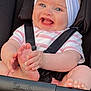 baby, smiling, blue_eyes, headband, heart_decoration, stroller, car_seat, happy, child, infant, cute, clothing, stripes, foot, hand, person, seatbelt, black_background, pink, white