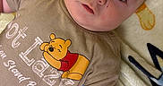 Cameron is registered to the contest to win money with this photo: baby, blanket, cartoon, child, clothing, comfort, cute, expression, eyes, face, indoors, infant, lying_down, person, shirt, skin, soft_texture, toddler, winnie_the_pooh, young_child