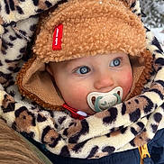 Léandre participe au concours pour gagner de l'argent avec cette photo : baby, child, face, blue_eyes, winter_clothing, hat, pacifier, scarf, leopard_print, fuzzy, snow, outdoor, cold_weather, cute, portrait, close_up, warm_clothes, jacket, red_cheeks, curious