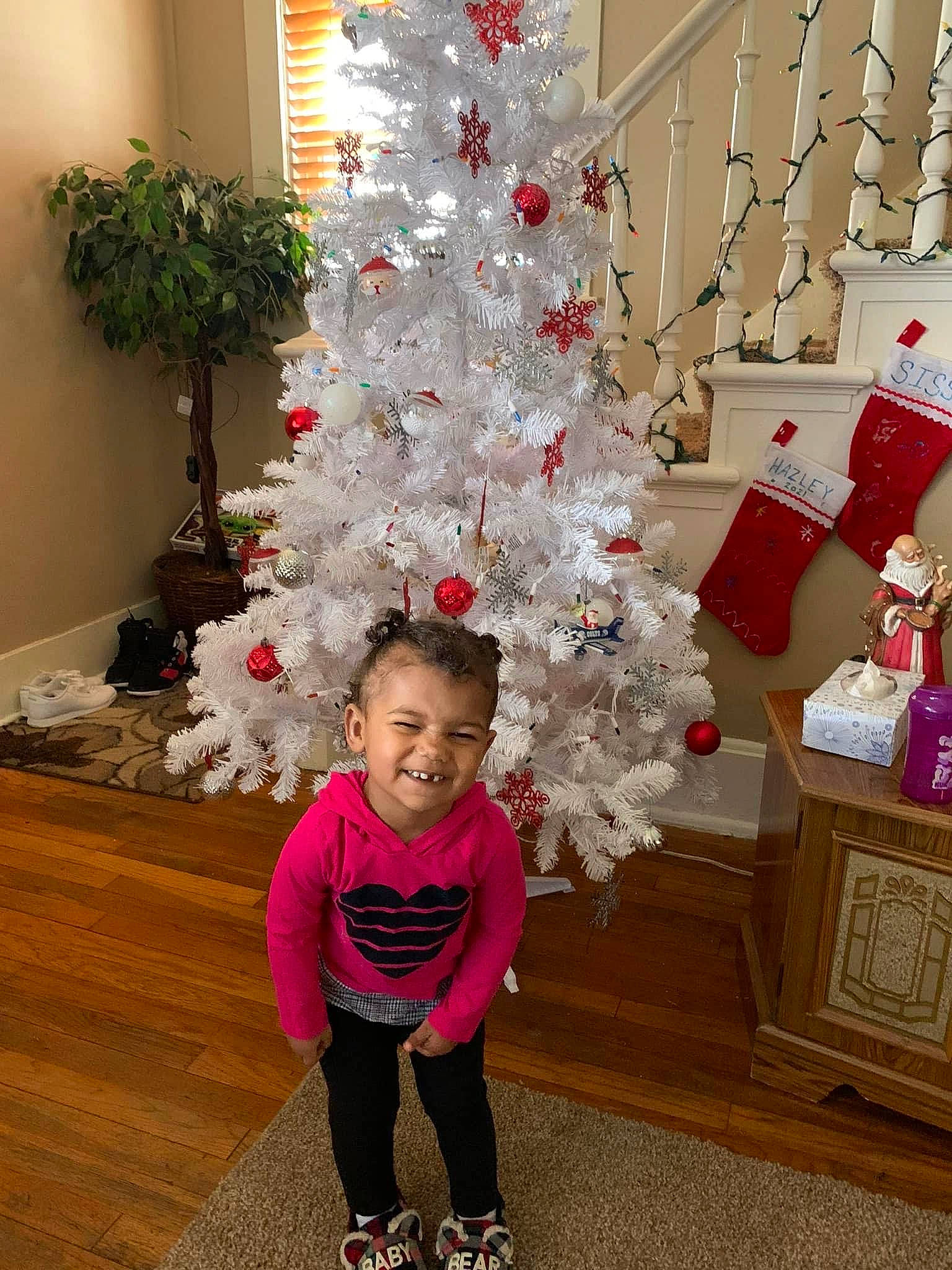 Hazley is registered to the contest to win money with this photo: baby_toddler_clothing, christmas, christmas_decoration, christmas_ornament, christmas_tree, conifer, decoration, event, evergreen, holiday, holiday_ornament, houseplant, joy, ornament, person, pink, plant, red, toddler, white