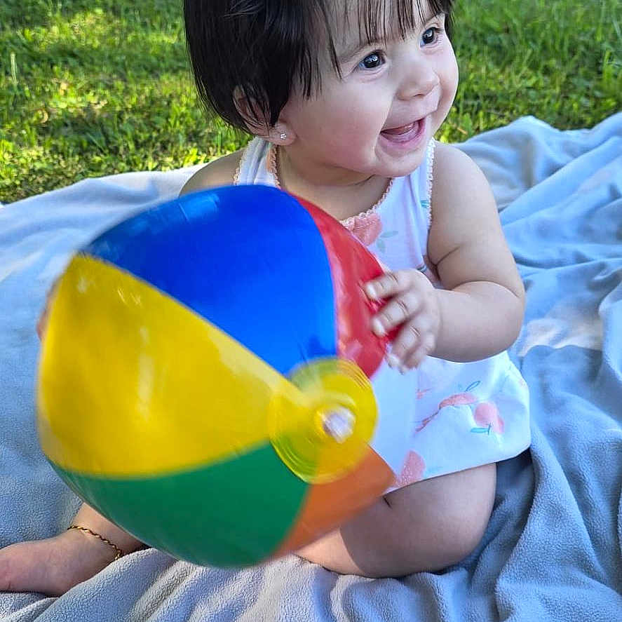 Danna joined the competition — help win amazing prizes! toddler, child, baby, smiling, outdoor, grass, blanket, beach_ball, happy, playful, summer, sunlight, cute, portrait, nature, garden, hair_clip, sitting, colorful, fun