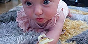 Maisie joined the competition — help win amazing prizes! baby, infant, pacifier, blue_eyes, pink_clothing, rug, fluffy_rug, living_room, sunflowers, fan, floor, cute, child, portrait, indoor, person, home, decor, curious, lying_down