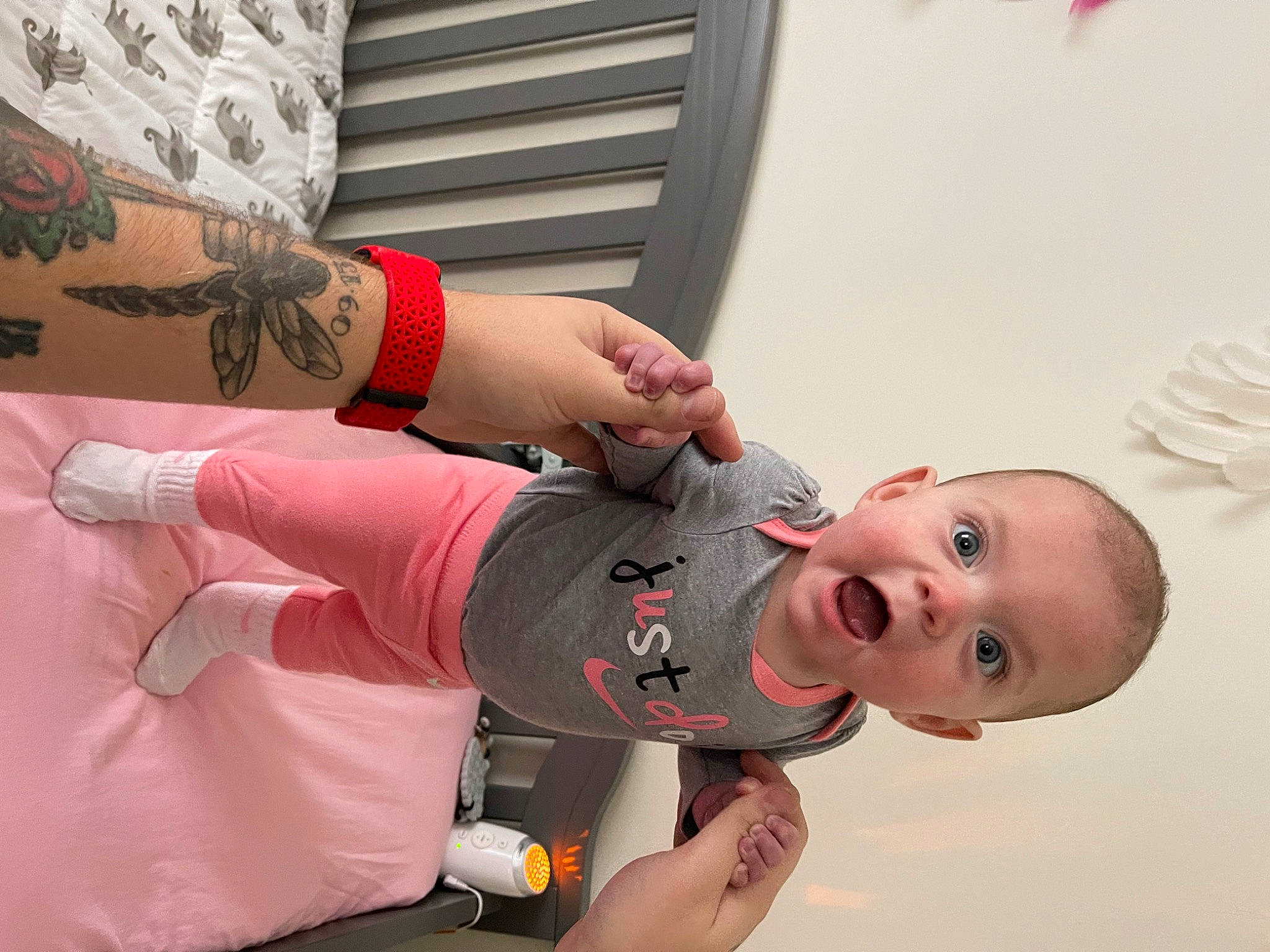 Faye is registered to the contest to win money with this photo: arm, baby, baby_toddler_clothing, elbow, finger, gesture, happy, human_leg, joint, knee, mouth, nail, neck, pattern, person, skin, sleeve, surprise, temporary_tattoo, thumb