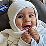 baby, child, smiling, knit_hat, blanket, cozy, indoors, happy, cute, portrait, clothing, infant, hands, warm, seat, furniture, face, expression, soft_texture, pom_pom