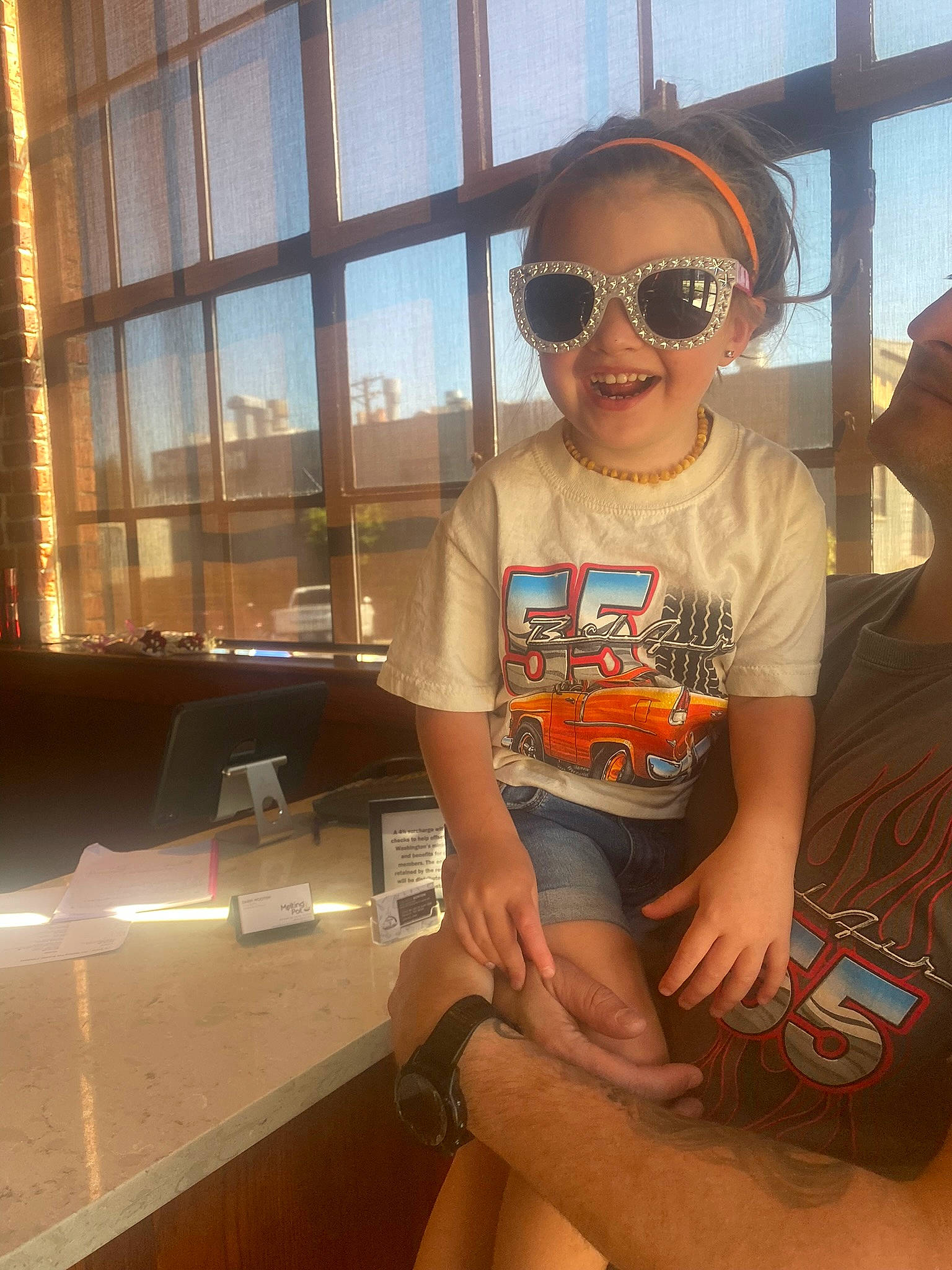 Harper is registered to the contest to win money with this photo: comfort, cool, eyewear, fun, glasses, goggles, happy, human_leg, joy, knee, lap, leisure, person, personal_protective_equipment, shorts, shoulder, sleeve, sunglasses, t_shirt, thigh