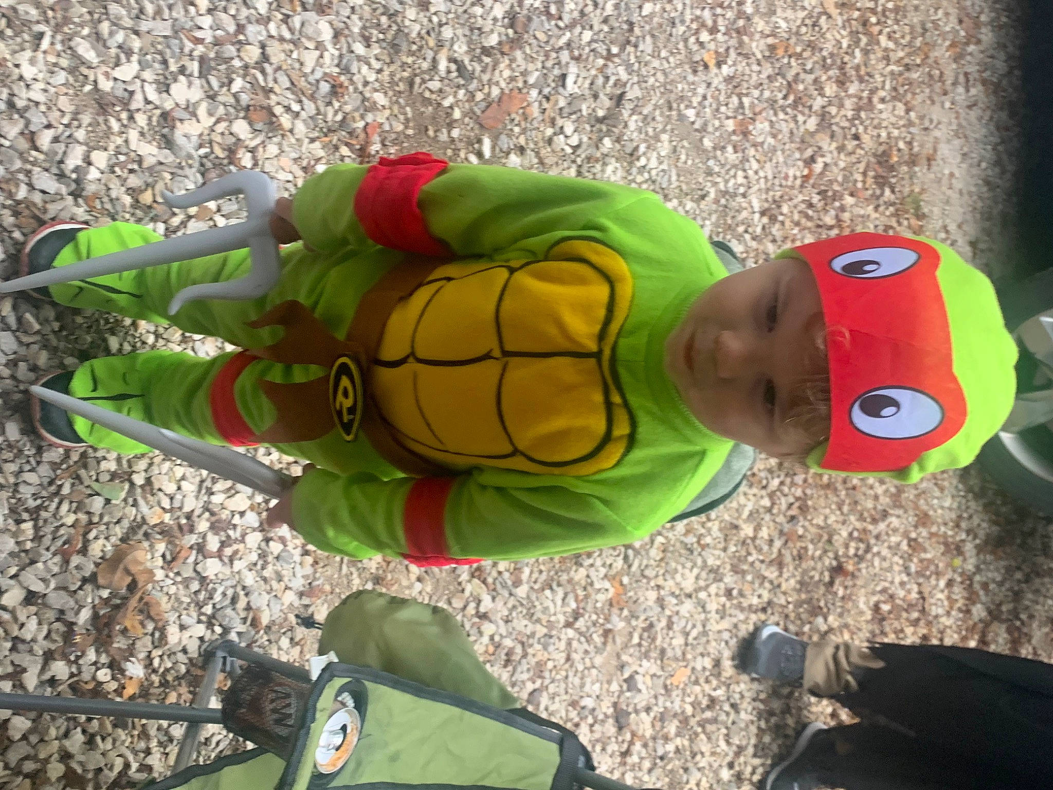 Cole is registered to the contest to win money with this photo: adventure, asphalt, child, fictional_character, fun, grass, headgear, headwear, leisure, organism, person, personal_protective_equipment, plant, play, recreation, soil, t_shirt, toddler, tree